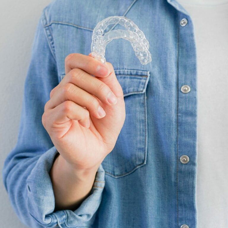 Person holding Invisalign aligners