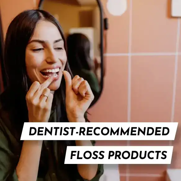 A woman flossing her teeth using one of Midtown Dental Group’s top dentist-recommended dental floss products, smiling in a clean, modern bathroom