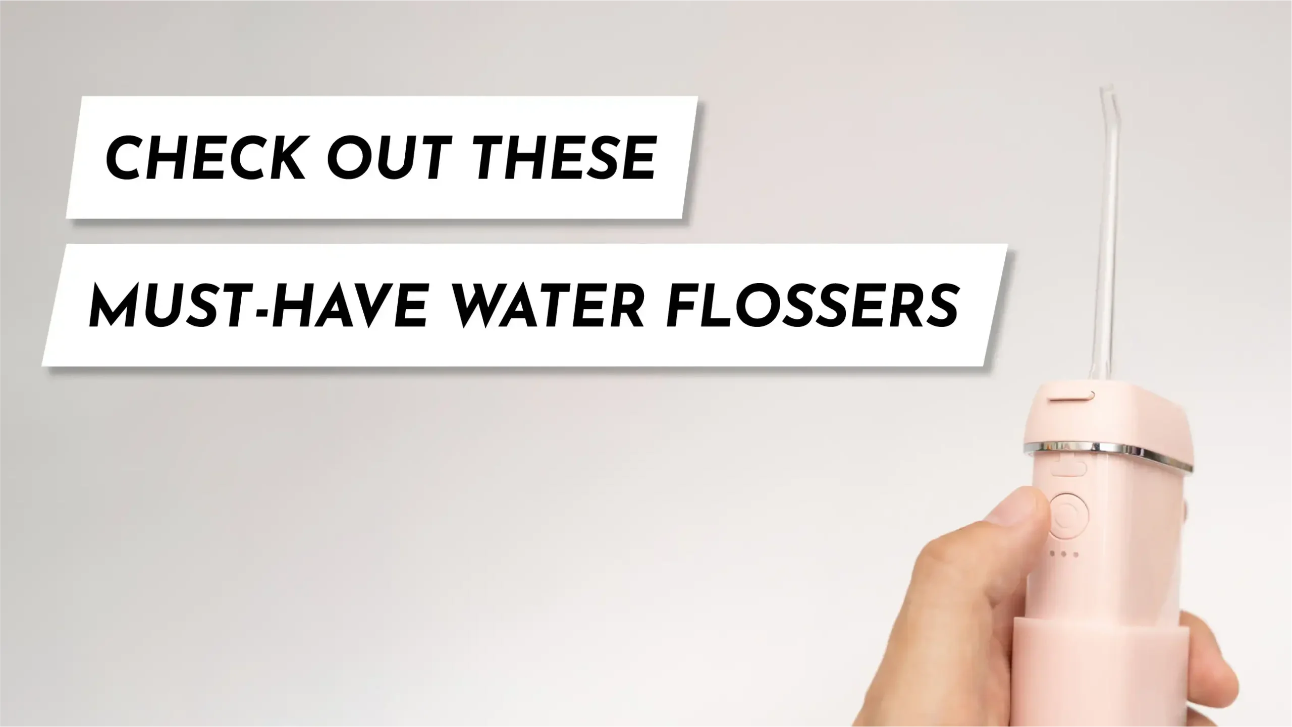 Close-up of a person’s hand holding a water flosser, preparing to clean between their teeth