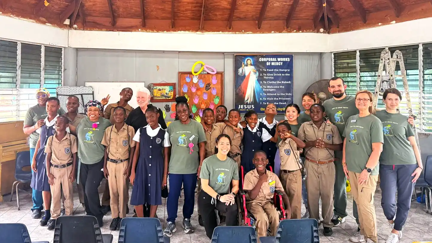 Midtown Dental Group team members posing with local children during their 2025 dental mission trip to Jamaica